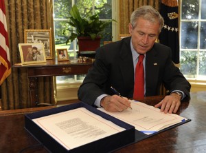 Bush signs the Emergency Economic Stabilization Act of 2008 in the Oval Office after the House passed the $700 billion financial rescue legislation in Washington