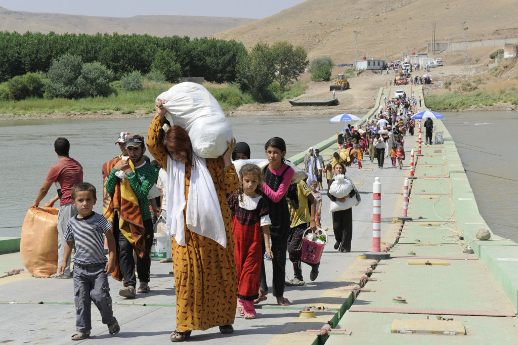 Displaced Iraqi Yazidis cross the Tigris from Syria into Iraq